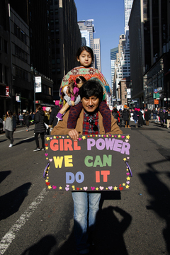 A parent and child walk the streets of New York City.