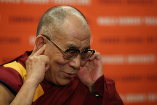 The Dalai Lama at the podium for a press conference before the One World Concert.