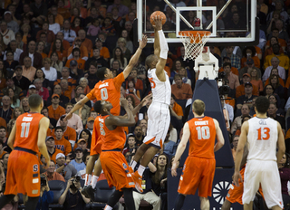 Mitchell dunks home two in front of a trailing Michael Gbinije. 