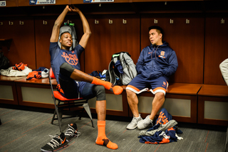 Strength coach Ryan Cabiles and SU center Bourama Sidibe chat in the locker room. 