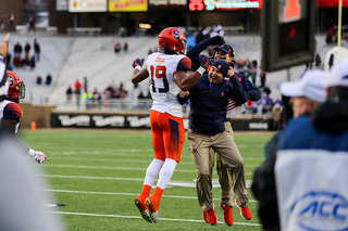 Andre Cisco celebrates with SU personnel on the sideline.