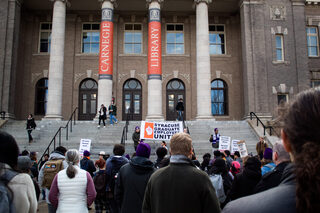 SGEU representatives Sadie Novak and Lauren Ashby start the march at the steps of Carnegie Library. The crowd and its energy quickly grew as protest leaders introduced a few chants and outlined the event. 