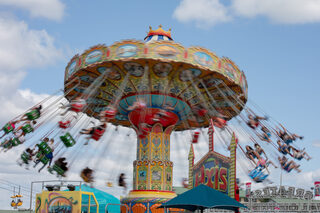 The NY State Fair Midway is home to rides and carnival games designated by a large illuminated sign that reads “Greatest Carnival on the Planet.” Axis was one of the several rides at the fair that featured a flying or twirling effect. 